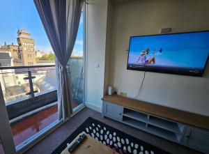 ein Wohnzimmer mit Flachbildfernseher und großem Fenster in der Unterkunft Cardiff City Apartment near Principality Stadium, Cardiff Arms Park & Cardiff Castle in Cardiff