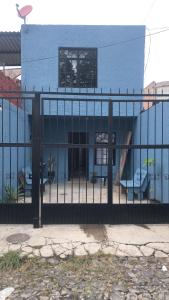 a fence in front of a blue building at casa completa centrica in Tonalá