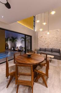 a living room with a wooden table and chairs at Casa KakMo in Izamal