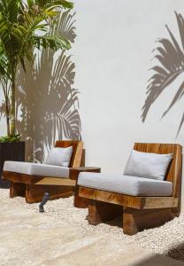 two wooden beds sitting in a room with plants at Casa KakMo in Izamal +38 photos