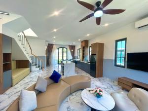 a living room with a couch and a ceiling fan at Villa NovaWorld Phan Thiết garden view, 3 BR for 6-8pax in Bình Tú