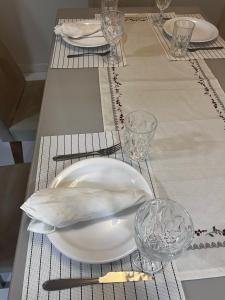a table with a white plate and glasses on it at Apartamento em Frente ao Shopping Itaguaçu in São José