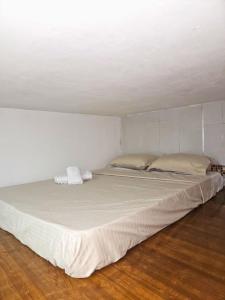 a large white bed in a room with a wooden floor at Apartaestudio - Miraflores in Cali