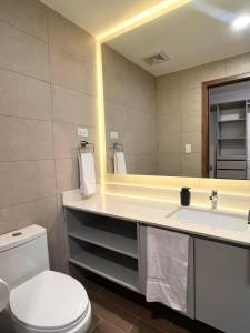 a bathroom with a toilet and a sink and a mirror at Luxury stay in zone 14 in Estación Pamplona