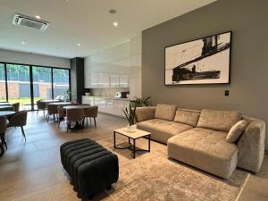 sala de estar con sofá, mesas y cocina en Luxury stay in zone 14, en Estación Pamplona