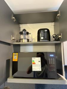 un forno a microonde con il riflesso di una persona al suo interno di Capibara 4 - Imponente vista al Río a Corrientes