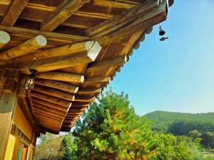 a wooden pergola on top of a house at Yangyang 88 Hanok Stay in Yangyang