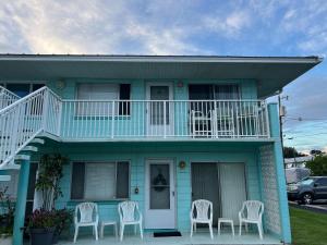 een blauw huis met witte stoelen ervoor bij Magical Mermaid Condo in New Smyrna Beach