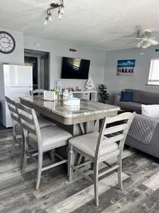 een keuken met een tafel en stoelen en een woonkamer bij Magical Mermaid Condo in New Smyrna Beach