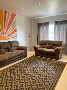 a living room with two couches and a rug at Bula Bliss Nadi - 2 Bedroom Apartment with Sunset View in Nadi