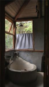 une salle de bain avec une grande baignoire et une fenêtre dans l'établissement Cabañas Bendita Tierra - Calandrias, à Los Molles