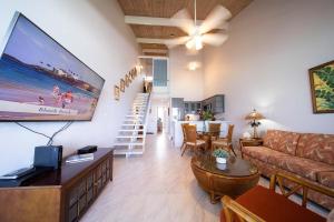 a living room with a couch and a large screen at Kulakane 306 · KK 306 Remodeled BeachFront 2BD w Ocean Views AC in Kahana