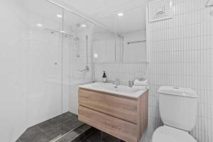 Un baño con inodoro, lavabo y ducha. en Seascape Serenity in Palm Beach, en Gold Coast