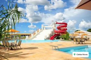 APT em CALDAS NOVAS في كالدس نوفاس: حديقة مائية فيها زحليقة مائية حمراء