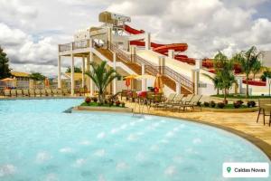 APT em CALDAS NOVAS في كالدس نوفاس: منزلق مائي في منتجع به حمام سباحة +صورتان