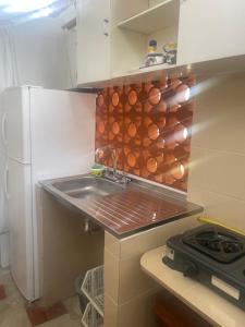 a kitchen with a sink and a refrigerator at La Casa de Luzma in Pueblo Bello