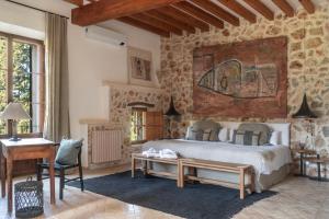 a bedroom with a bed and a stone wall at Agroturismo Son Fogueró - Adults Only in Maria de la Salut