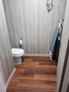 a bathroom with a toilet and a wooden floor at ICHA Apartments in Suva +2 photos