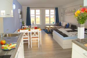 a kitchen and living room with a bed and a table at familiäre Ferienwohnungen in Röbel an der Müritz in Röbel