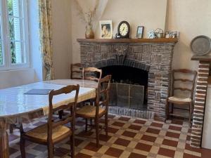 a dining room with a table and a fireplace at Maison de maître XIXe avec piscine partagée et jardin à Gipcy - FR-1-489-504 in Gipcy
