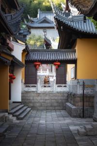 een persoon die voor een gebouw zit bij SSAW Garden Hotel Ningbo Xikou in Fenghua