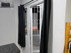 a window in a room with black curtains at Cantinho Fátima - Kitnet aconchegante próximo ao Santuário Nacional in Aparecida