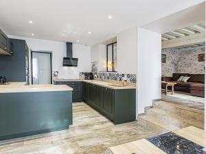 a kitchen with green cabinets and a living room at Gîte de l'Argonne - FR-1-491-391 in Cheverny