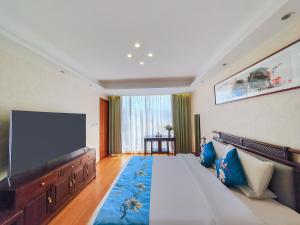 a bedroom with a large bed and a flat screen tv at Boying happywin Guofeng Shangyuan Lijiang Ancient Town South Gate Store in Lijiang