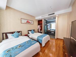 a hotel room with two beds and a television at Boying happywin Guofeng Shangyuan Lijiang Ancient Town South Gate Store in Lijiang