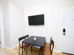 a dining room with a table and a tv on a wall at Comfy 1-Bedroom Escape Close to NYC with Wifi in Paterson
