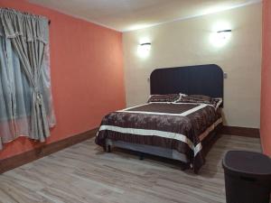 a bedroom with a bed in a room with orange walls at Casa Cifuentes in La Esperanza