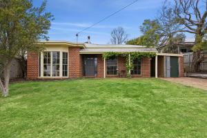 una casa di mattoni con un prato di fronte di Riviera Retreat, Coastal Comfort Near Jan Juc Surf Beach a Bellbrae