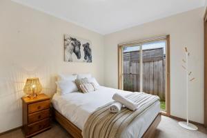 una camera da letto con un letto grande e una finestra di Riviera Retreat, Coastal Comfort Near Jan Juc Surf Beach a Bellbrae