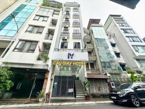 een hoog wit gebouw met een bord waarop staat 'calgary hotel' bij Capital CauGiay Hotel in Hanoi