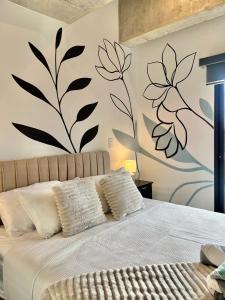 une chambre avec un lit avec une fresque florale sur le mur dans l'établissement Urban Corner in Zone 4, à Guatemala