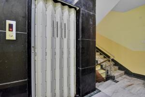 an elevator with white doors in a room with stairs at Hotel O Om Shanti International in Jādabpur