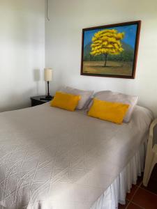 a bedroom with a white bed with yellow pillows at La Casa de Luzma in Pueblo Bello +16 photos