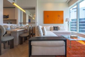 una sala de estar con un sofá y una mesa en Maison Privee - High-Floor Haven with Open Sea Views on Palm Entry, en Dubái