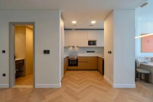 cocina abierta con paredes blancas y suelo de madera en Maison Privee - High-Floor Haven with Open Sea Views on Palm Entry, en Dubái 11 fotos más