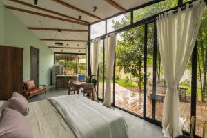 a bedroom with a bed and a large glass window at Romantic Mirror-Clad Tiny with Private Hot Tub in Pedro Ruiz Gallo