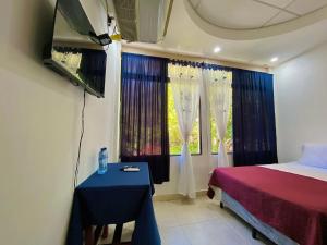 a bedroom with a bed and a table and a window at Hotal D Palacio Real in San Miguel
