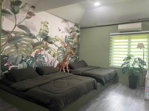a bedroom with two beds and a mural of a giraffe at Kerlingfornia Kiddo Kingdom in Kerling