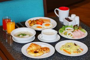 a table with plates of breakfast food on it at Century Park Hotel in Bangkok +111 photos