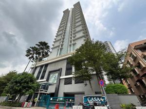 a tall building with a clock in front of it at Casa Residency Bukit Bintang by PILLOWTALKS in Kuala Lumpur