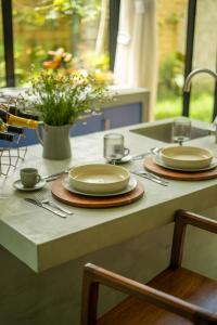 a table with plates and cups and a sink at Romantic Mirror-Clad Tiny with Private Hot Tub in Pedro Ruiz Gallo +35 photos