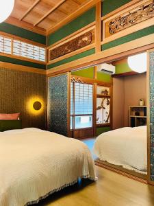 a bedroom with two beds and a large window at Anju KAGUYA 香宮宿 in Katori