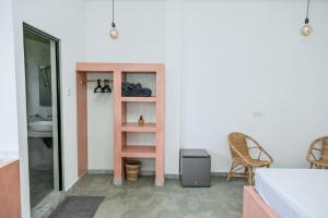 ein Schlafzimmer mit einem rosa Schrank und einem Stuhl in der Unterkunft Rise - Bed & Breakfast in Weligama