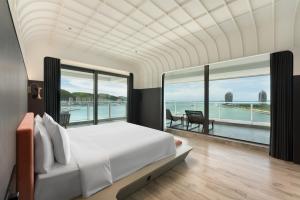 Un dormitorio con una cama y vista al agua. en Vignette Collection Tiancheng Belmont Hotel Sanya by IHG, en Sanya 46 fotos más