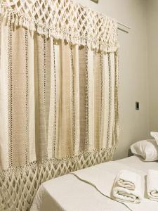 a bedroom with a window with white lace curtains at Pousada da Ana in Estivado