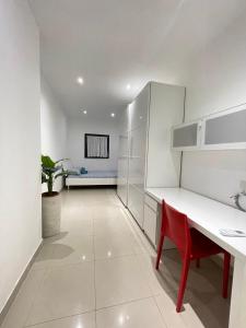 a kitchen with white cabinets and a red chair at Modern Gzira 2BR Apartment Race2 in Il-Gżira